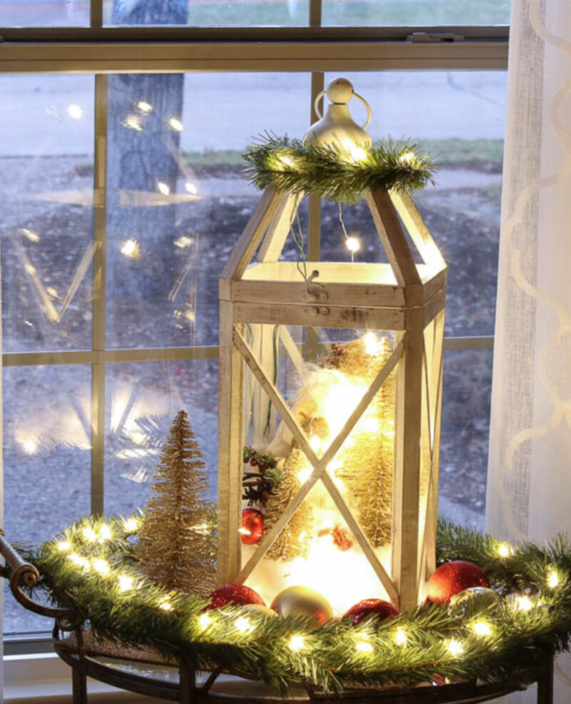 white wood lantern filled with Christmas lights