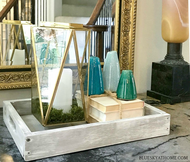 brass and glass lantern with candle and books