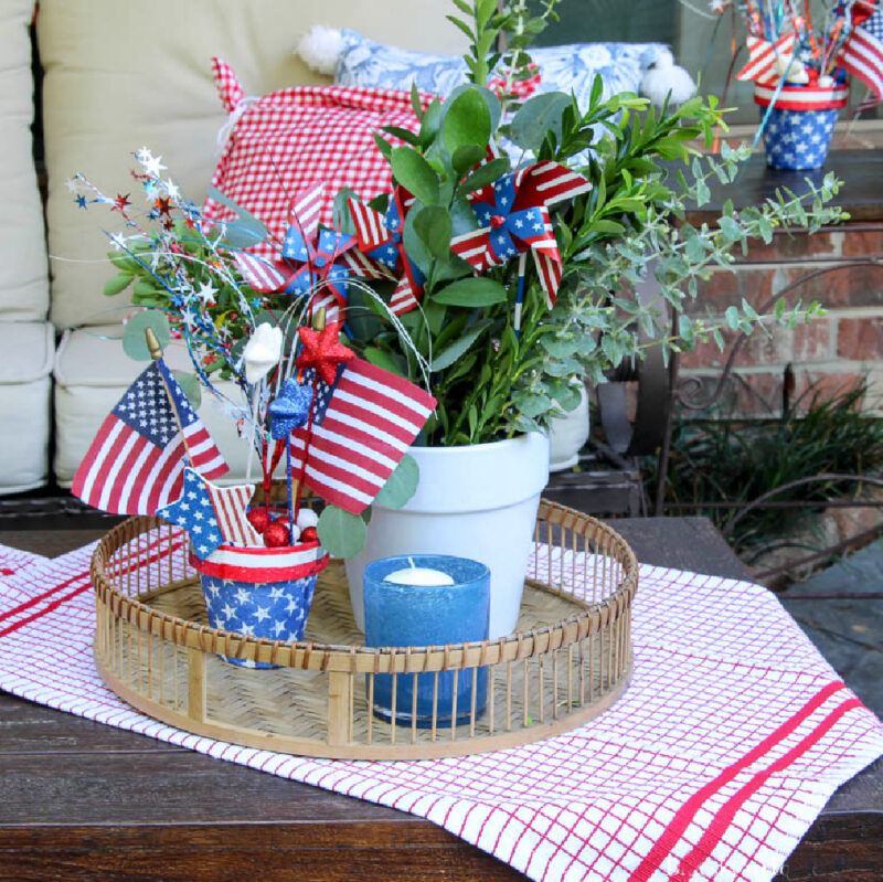 red, white and blue 4th of July vignette in woven round basket on patio table
