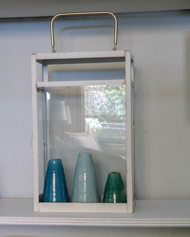 blue and green vases inside metal and glass lantern