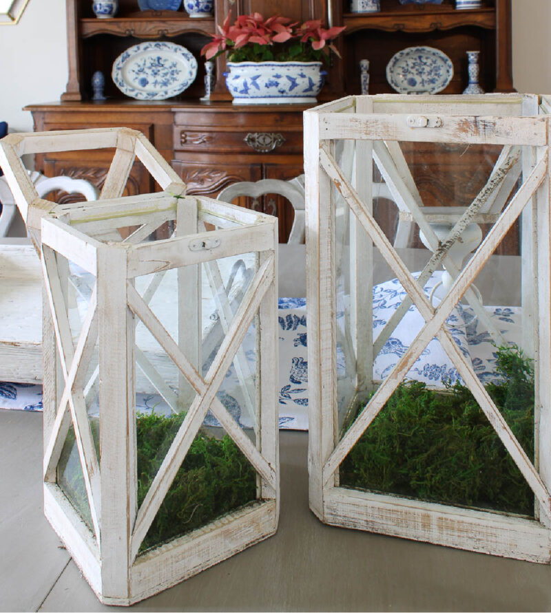 pair of white wood lanterns on table