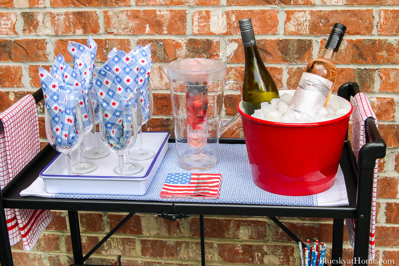 style a bar cart with red ice bucket with 2 bottles of wine