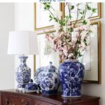 display of blue and white chinoiserie on chest in entry with botanical art