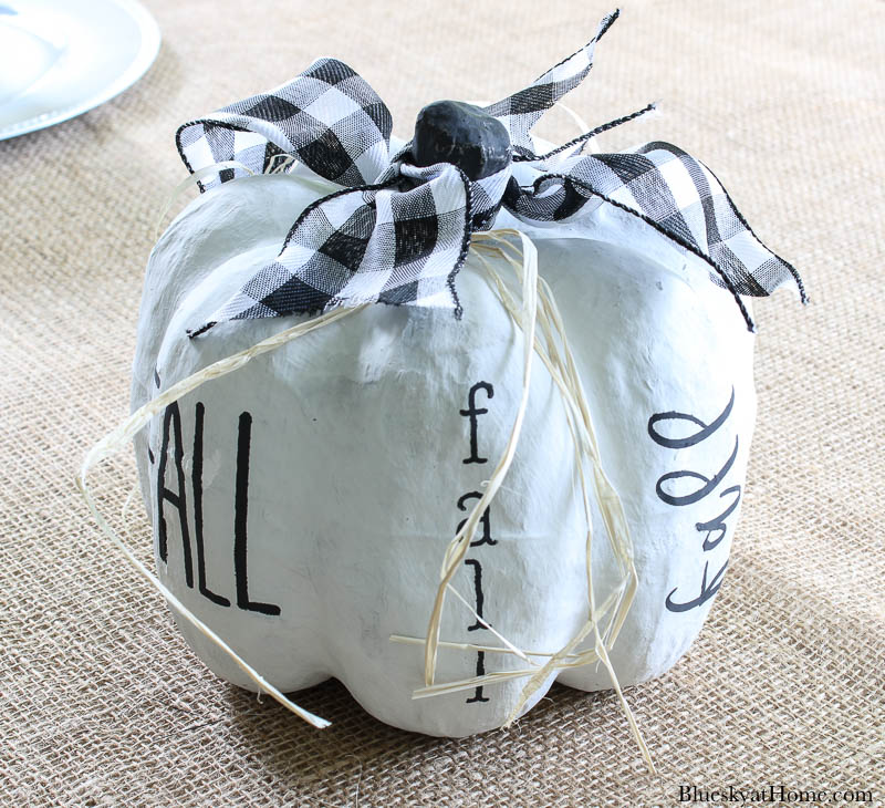 white painted pumpkin with black stencil word fall