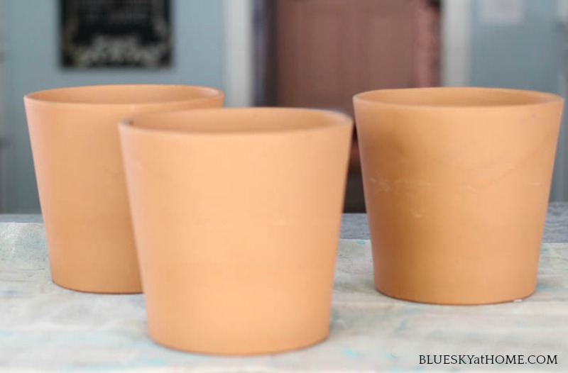 three terra cotta pots on counter