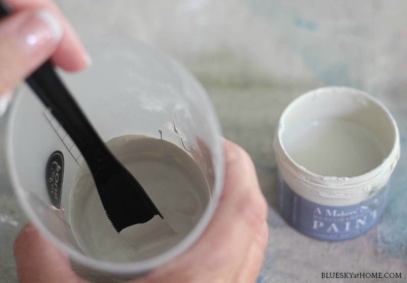 stirring sand and water in plastic cup