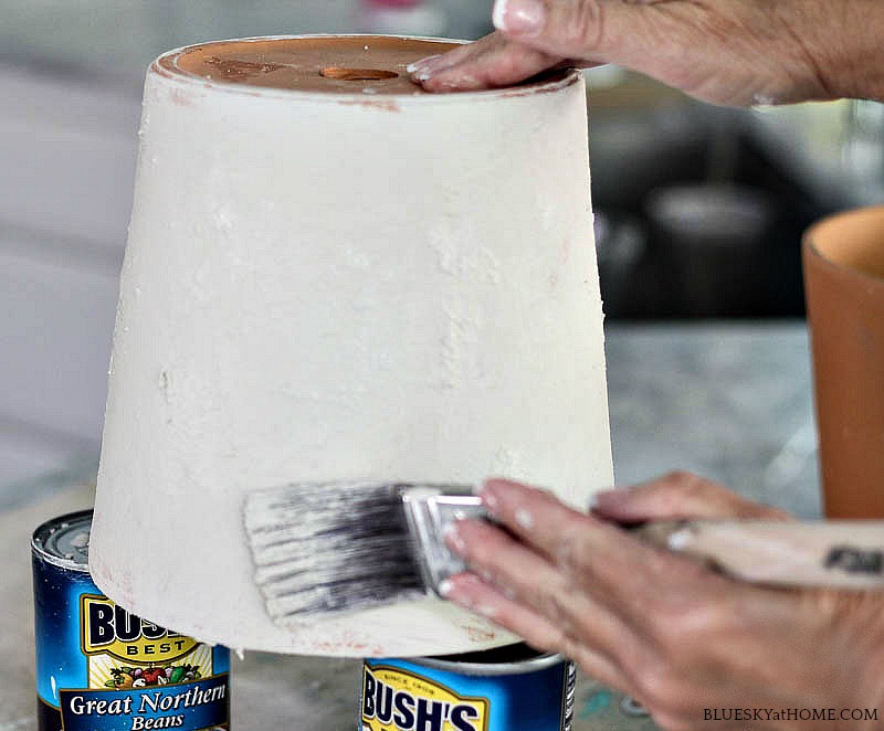 painting sanding paint on terra cotta pot.