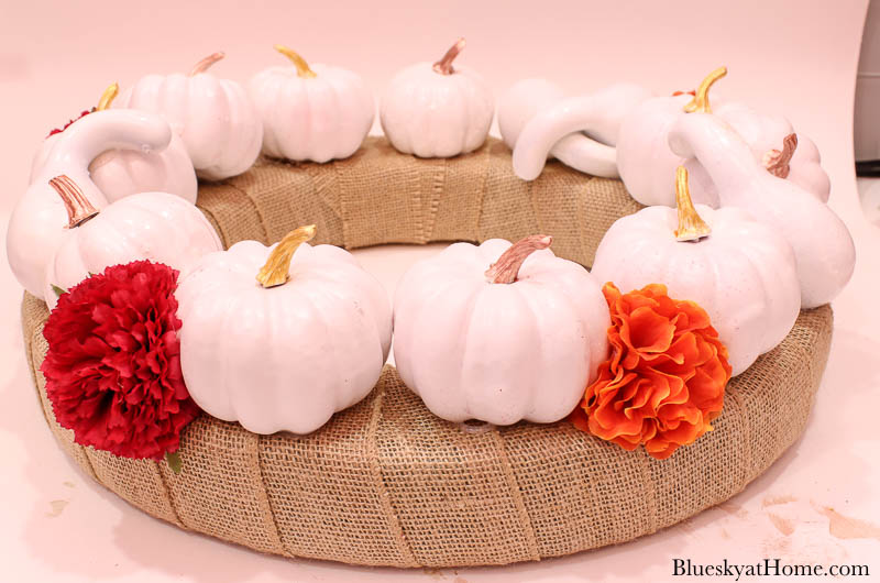 white pumpkins on burlap wreath with faux flowers