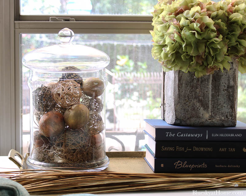 glass jar and dried hydrangeas in grain scoop on fall decorated table