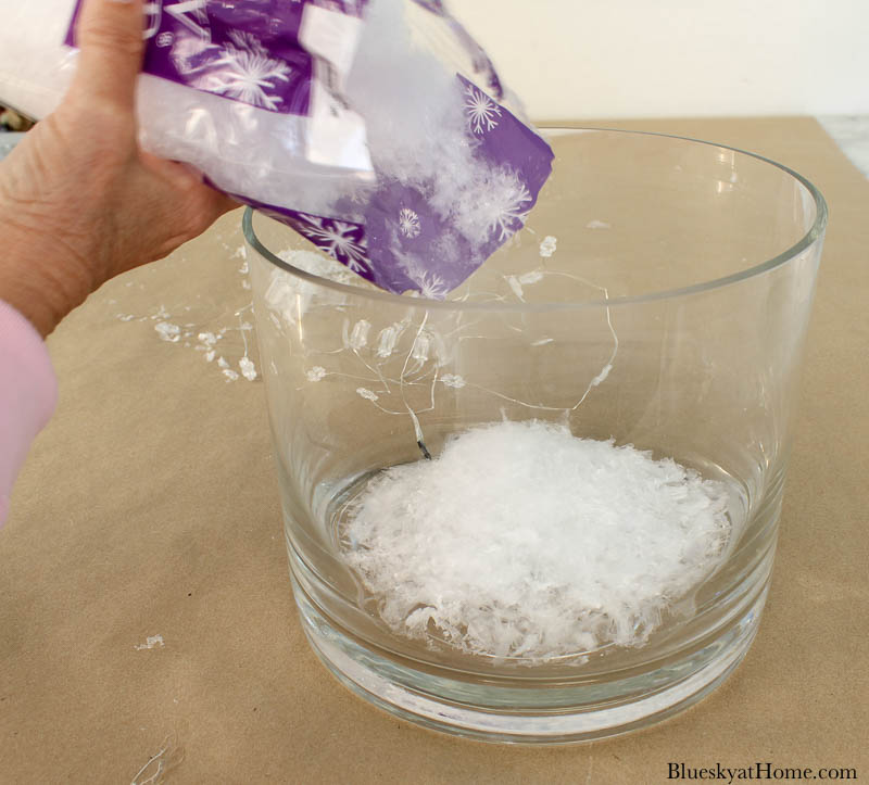 pouring faux snow into glass jar