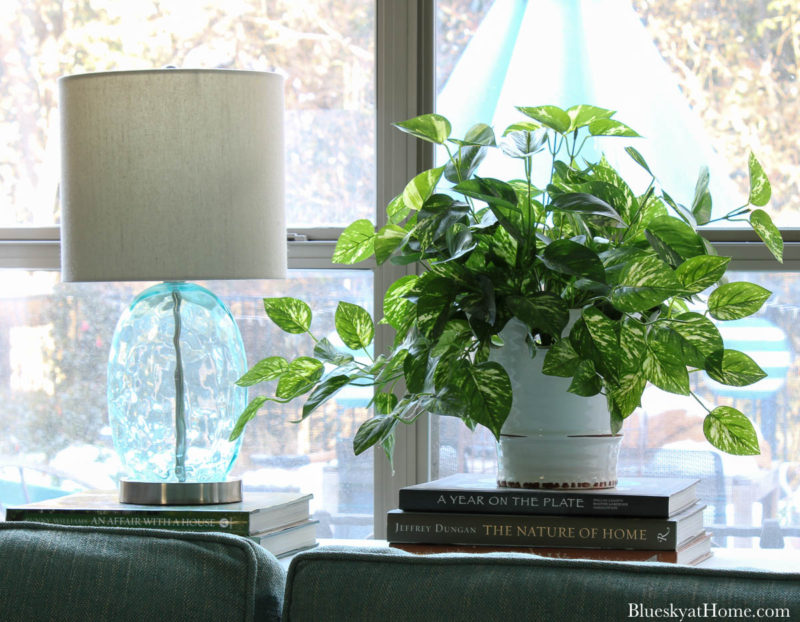 green pothos ivy in white container and aqua table on sofa table