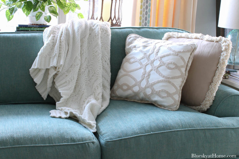 pillow and throw on aqua sofa