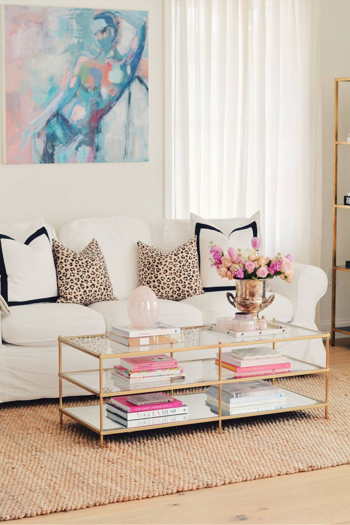 white sofa with pink accessories and pink flowers