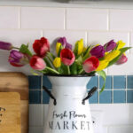 stencil on farmhouse pitcher with colorful tulips