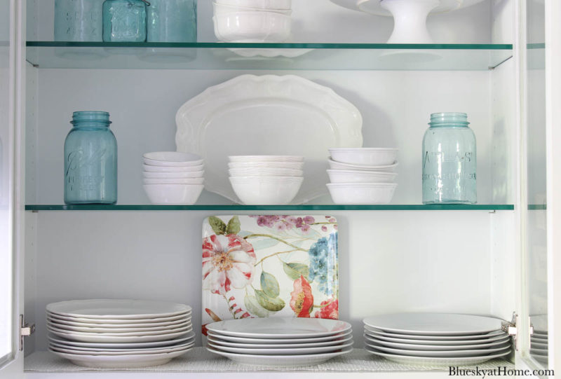 shelves with white dishes and blue mason jars for spring kitchen