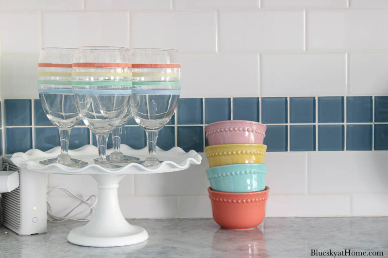 cake stand with glasses and bright pastel bowls