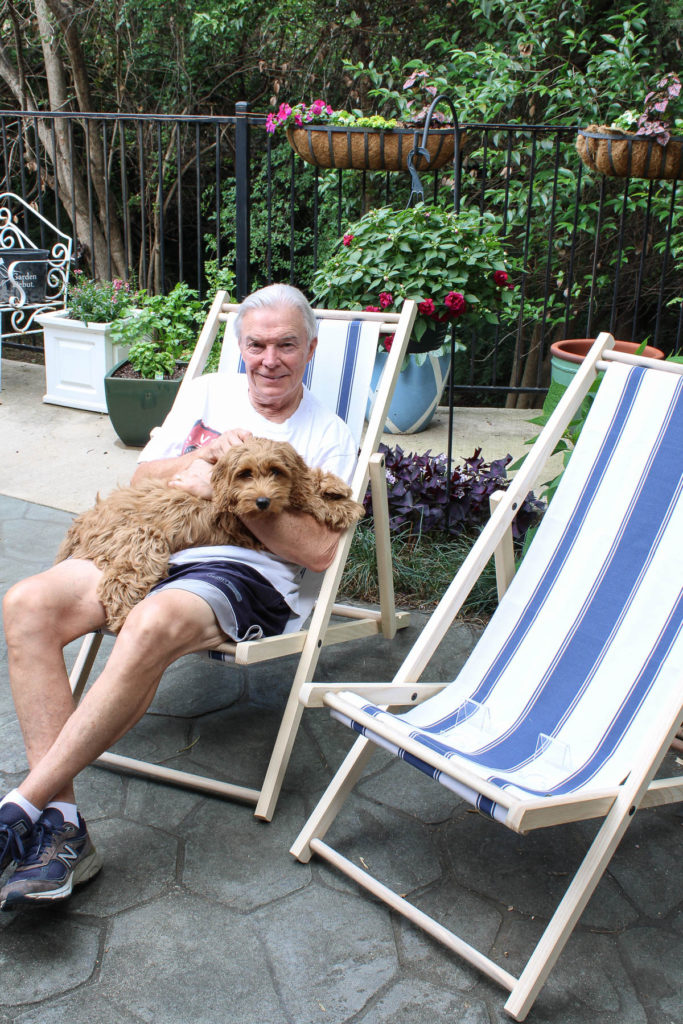 man in cabana chair with dog