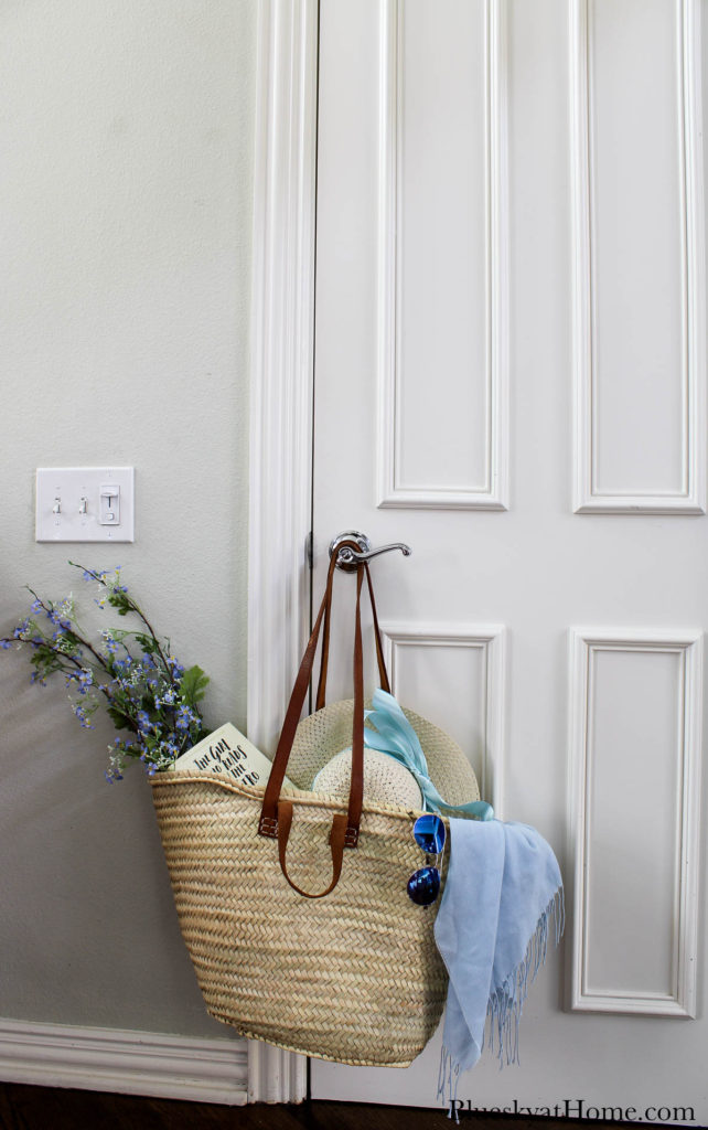 woven French market tote hanging on door knob