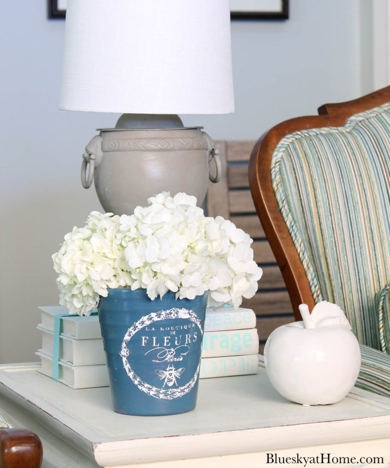 painted blue ceramic flower pot with white hydrangeas on table