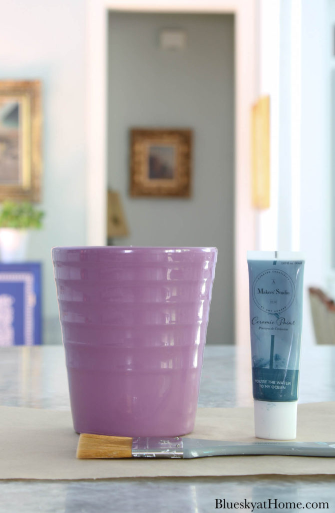 mauve ceramic flower pot and tube of blue ceramic paint