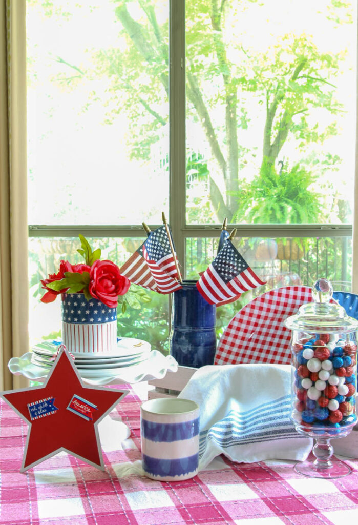 blue plates with stars and red check plates with red check dishtowel and apothecary jar with red, white and blue balls