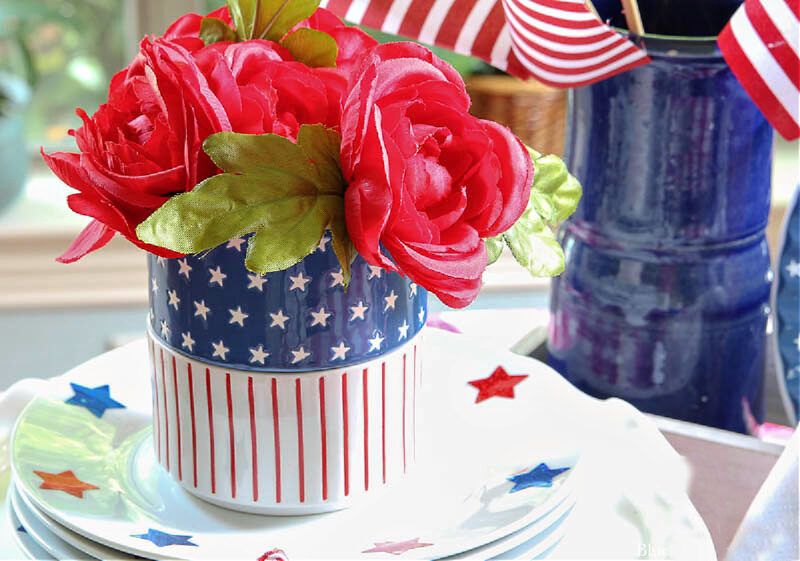 red faux flowers in red, white, and blue container