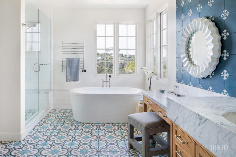  blue wallpaper in bathroom with blue pattern tile floor and blue towel