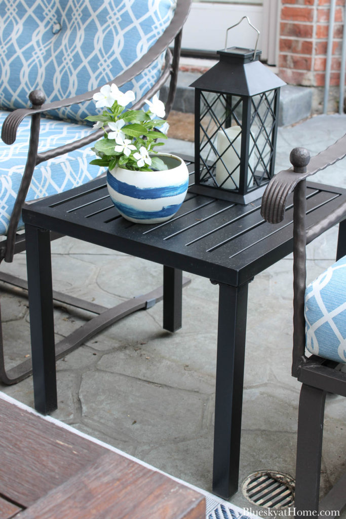 black metal patio table with pot of flowers