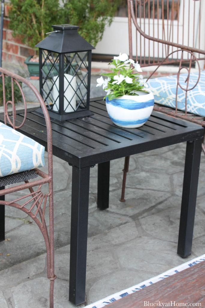 black metal patio table with pot of flowers