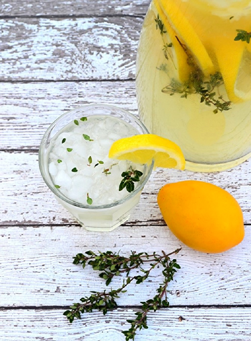 pitcher of lemon thyme wine spritzer with lemon 