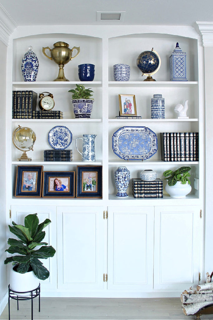 white built-in bookcase with blue accessories, books, and photos