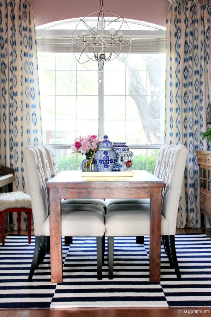 dining room with blue and white drapes, blue and white stripe rug, and blue decorative accessories