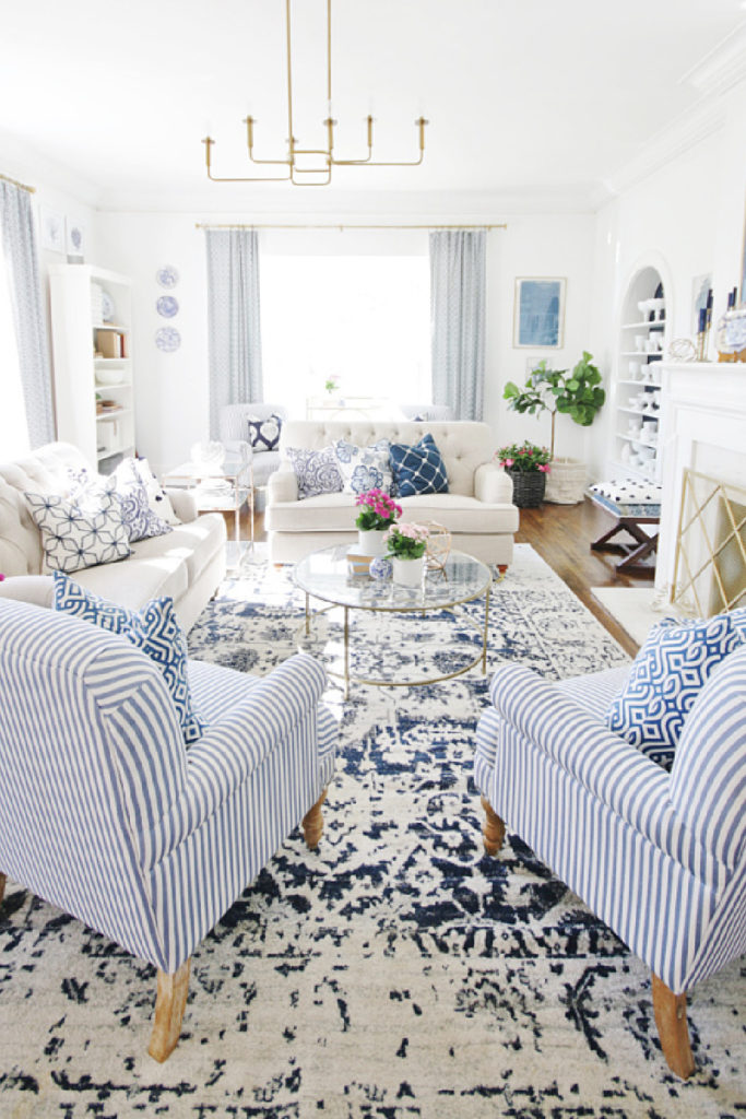 formal living room with blue rug, pillows, throw, and decorative accessories