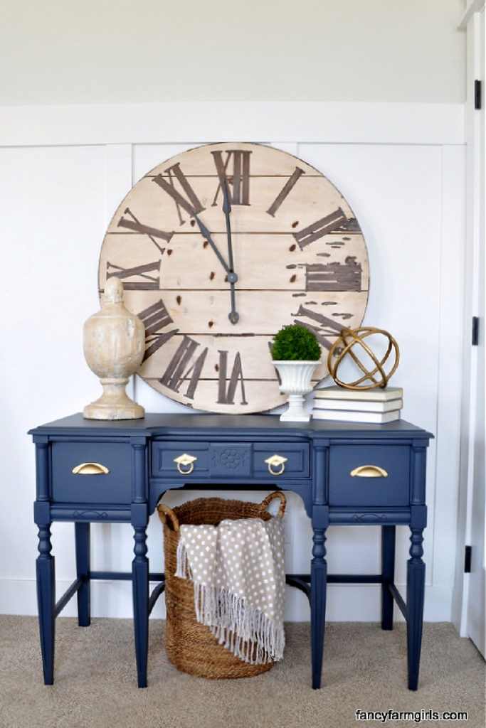 blue painted desk with large vintage clock and books