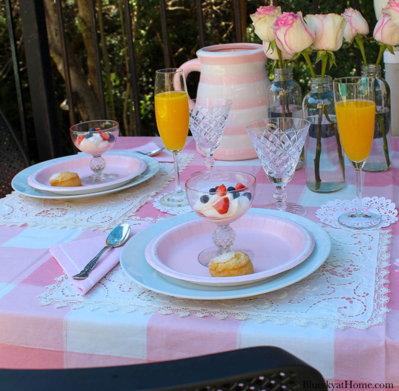 pink roses in bottles on pink table setting