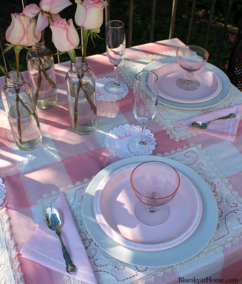 pink roses in bottles on pink table setting