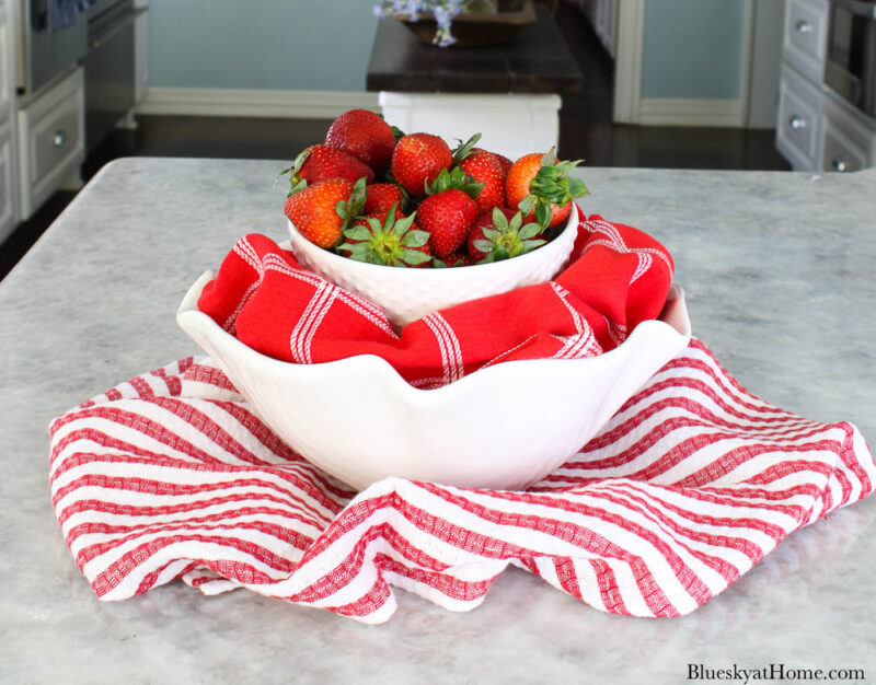 strawberries in white bowl with red check towel