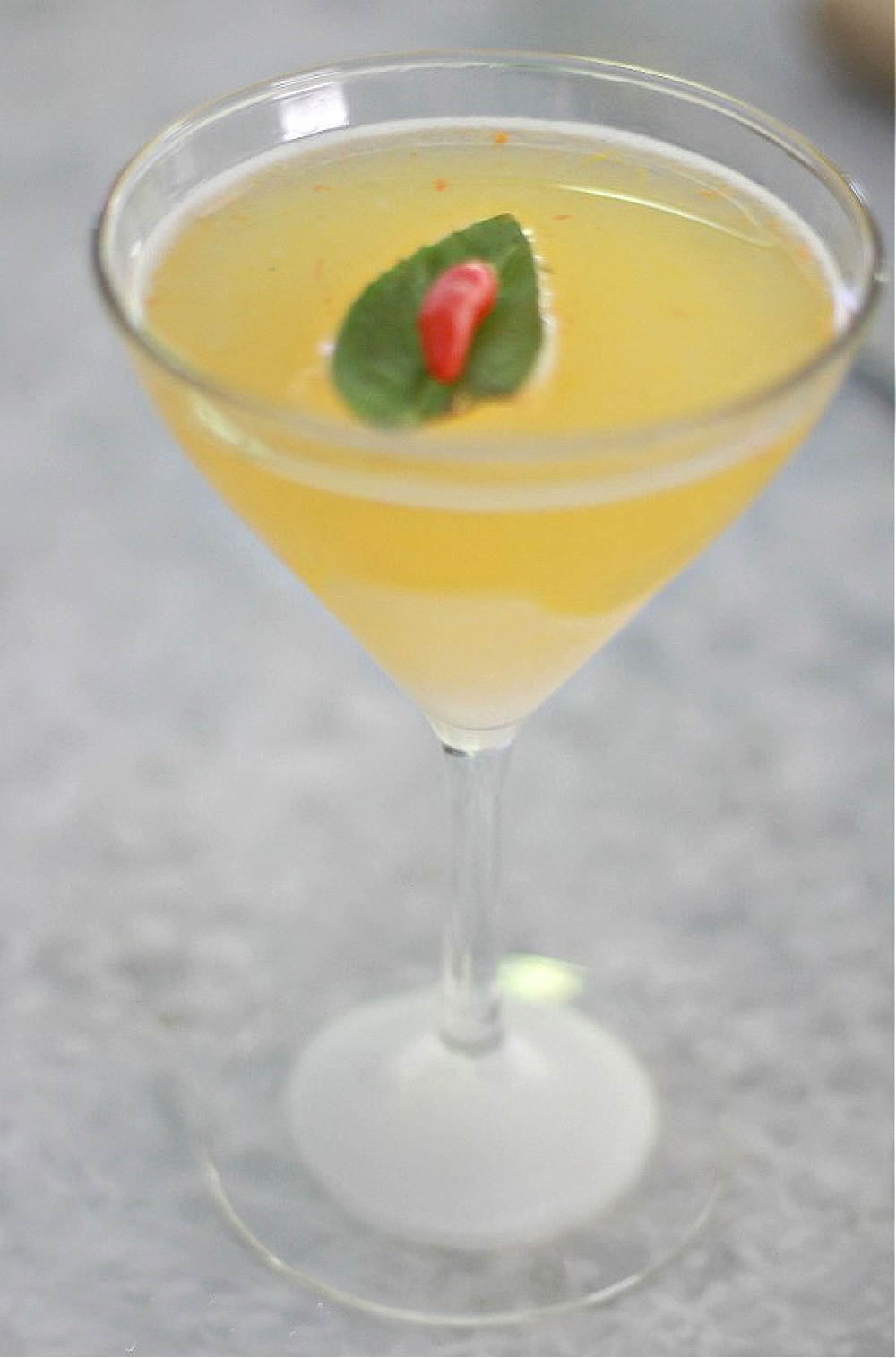 Clementina cocktail yellow with red pepper on a green basil leaf