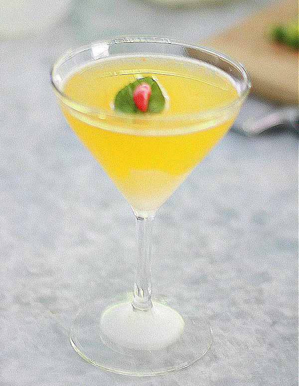 Add-Some-Heat-to-Your-Drink-with-a-Clementina Clementina cocktail in martini glass with mint leaf and pepper garnish