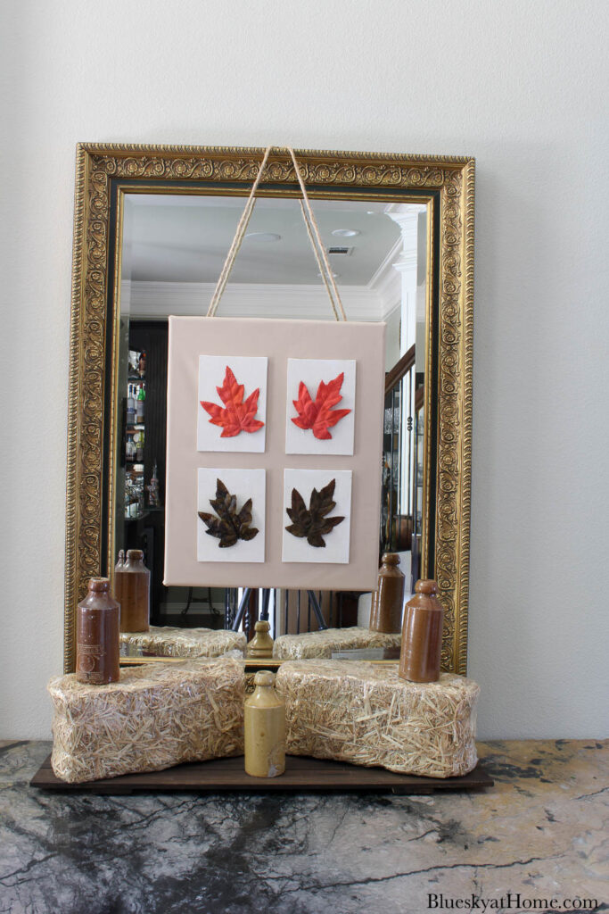 4 fall leaf canvases on large canvas hanging on mirror
