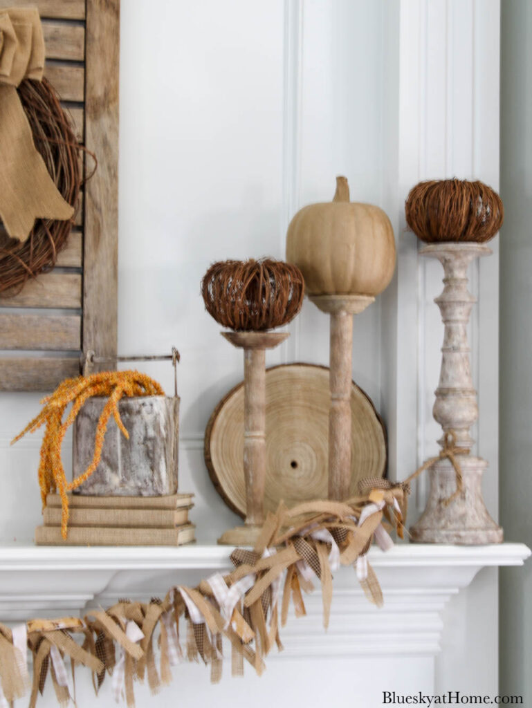 netural pumpkins on candlesticks on fall mantel