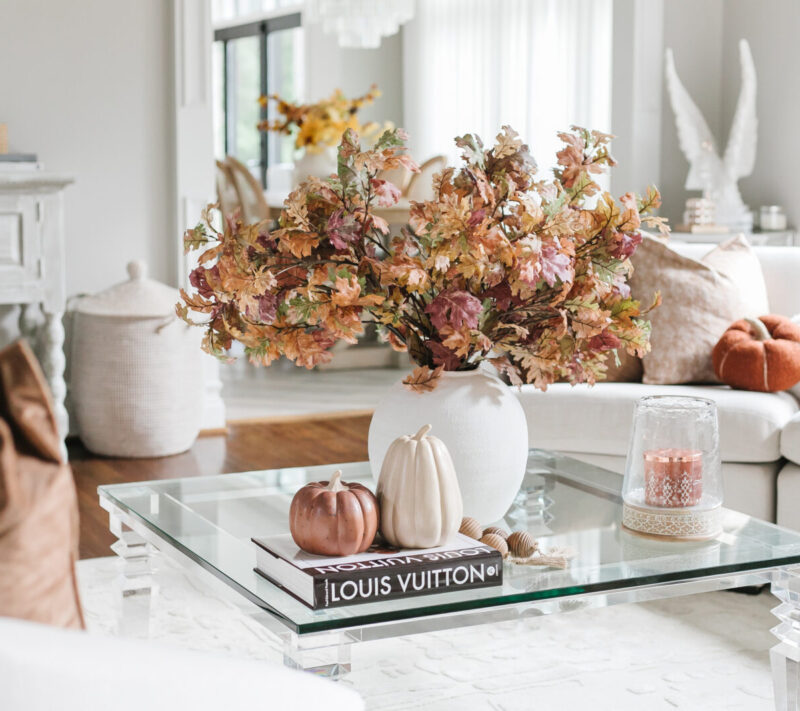 fall faux foliage in white vase on coffee table with neutral pumpkins and books