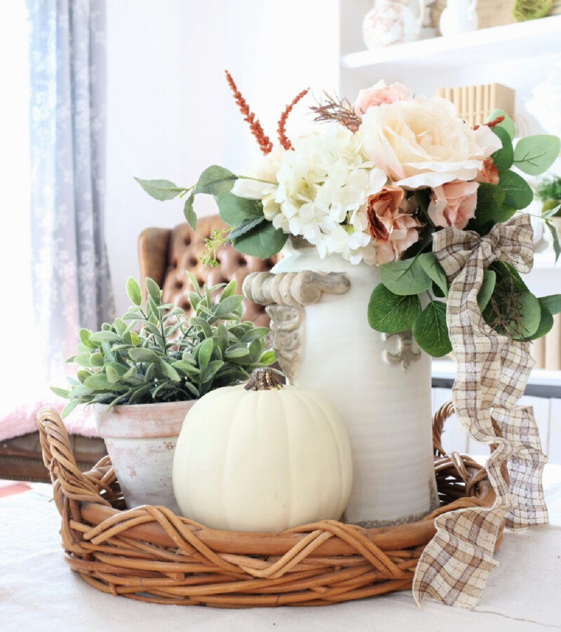 fall display of white vase and pumpkin
