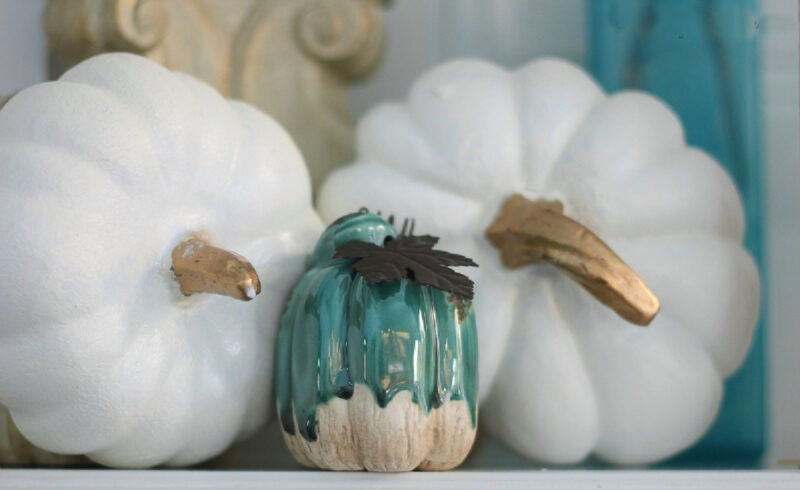 white painted pumpkins on mantel