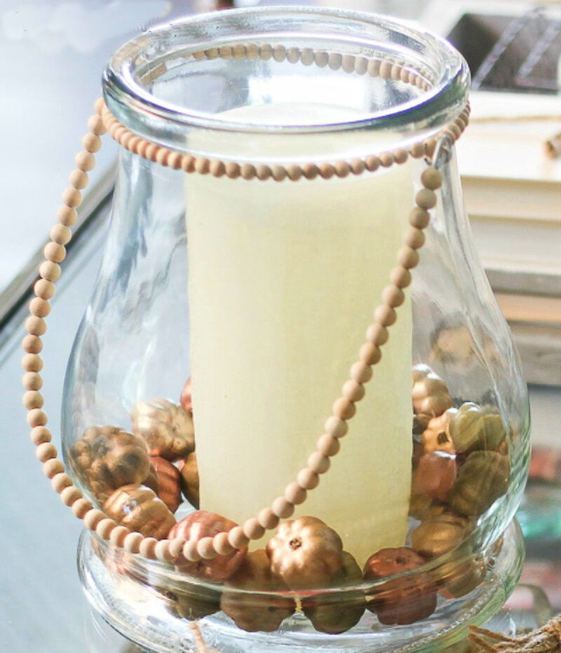 glass jar with candle and painted pumpkins