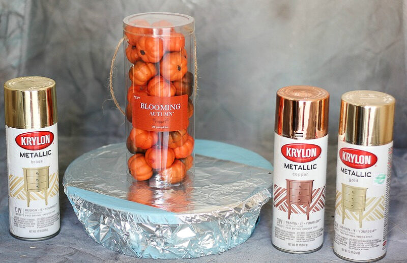 package of small orange pumpkins with spray paint