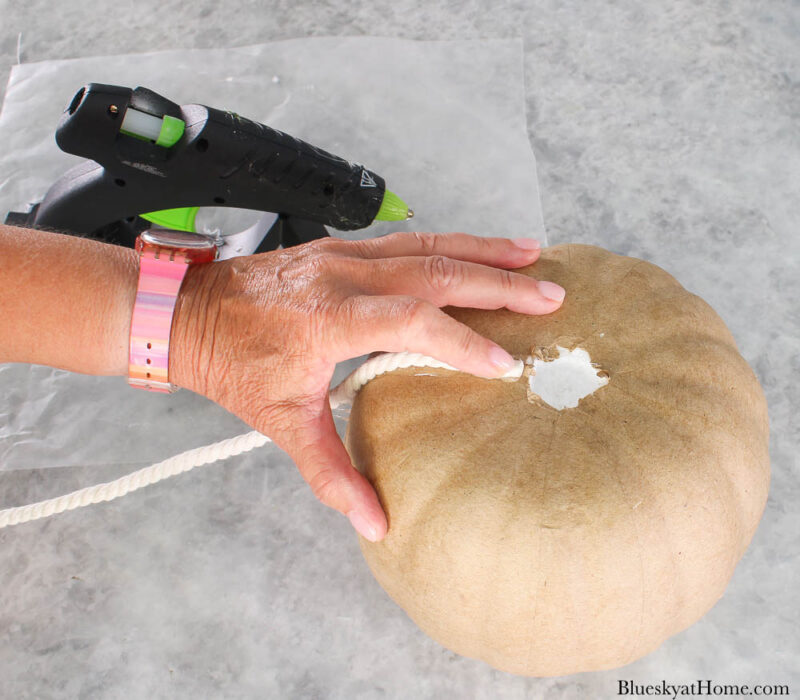 gluing white rope to paper maché pumpkin