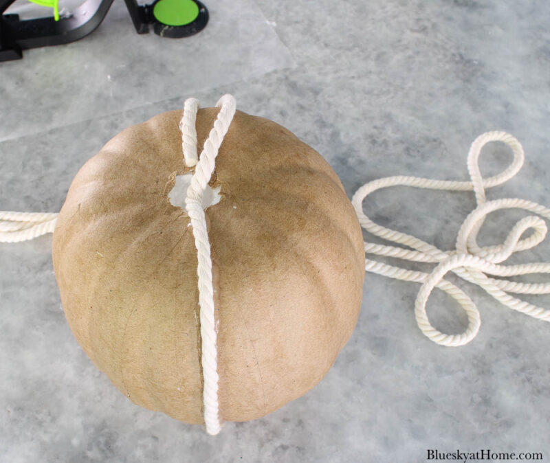 gluing white rope to paper maché pumpkin