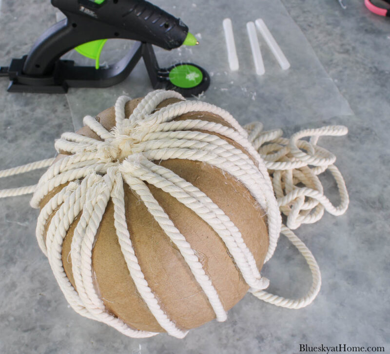 gluing white rope to paper maché pumpkin