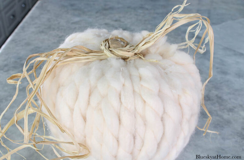 raffia tied to pumpkin with yarn